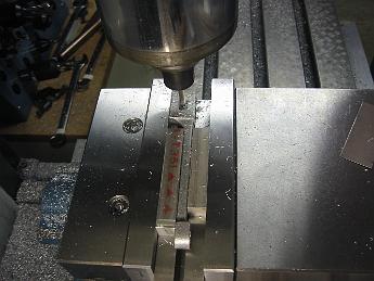 ValveGear10Dec08 003 It's hard to hold Combination Lever with an offset in the vise, so a couple of blocks are used to pinch the part in the jaws.  Then we mill the slot in a conventional horizontal position.