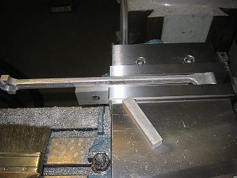 ValveGear10Dec08 004 We had some discussions on how to hold the Eccentric Rod to mill the slot.  In the end we decided to just clamp it in the vise and mill the middle away.  The risk of this setup is the vise might put force on the tiny amount of material not machined away, causing the machined part to bend or have taper when done.