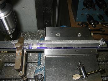 ValveGear3Dec08 002 Next it's a simple step to drill and bore the holes.  Not seen is the machinist's jack to support the end of the fixture hanging out of the vise.