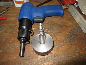 RivetingBuck6May09 002 The finished buck and air hammer rivet set.  I would recommend you get a 'palm nailer' instead of the pistol style hammer. Holding the gun is hard on the wrist after a bit.  We heated and tempered the buck after this picture was taken, this will help it keep the correct head profile.