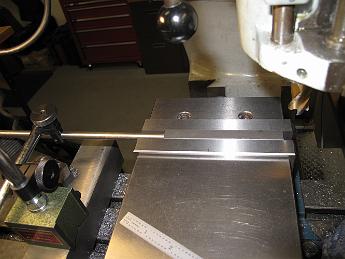 SmokeboxRunningBoardBrackets10June09 001 10-June-09 We start on the smokebox running board brackets.  Bill has machined four pieces of stock to size and has stop set up for in the vice to make the identical pieces.  This allows him to put the next piece in the vice and not have to re-indicate the location. Just clamp and re-use the same numbers on the dial!