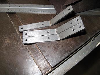 SmokeboxRunningBoardBrackets10June09 003 The first 45 degree bend is completed for three pieces and I sneak a picture while the fourth is bent.  After this a 90 degree bend is put on the ends with the two close holes.